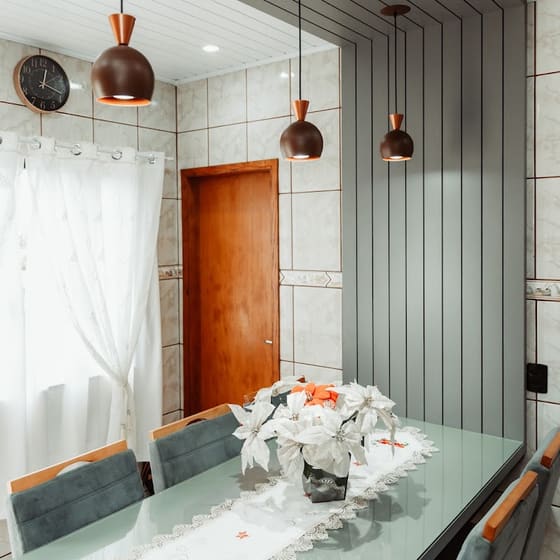 Sala de jantar com painel ripado planejado e pendentes cobre